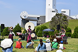 和太鼓グループ彩の写真。２人が太鼓を叩き、１人が笛を吹いています。